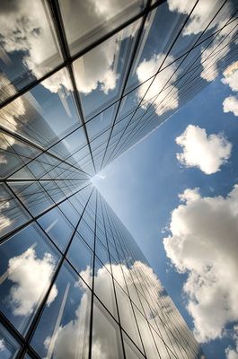 sky and clouds reflected in a glass building