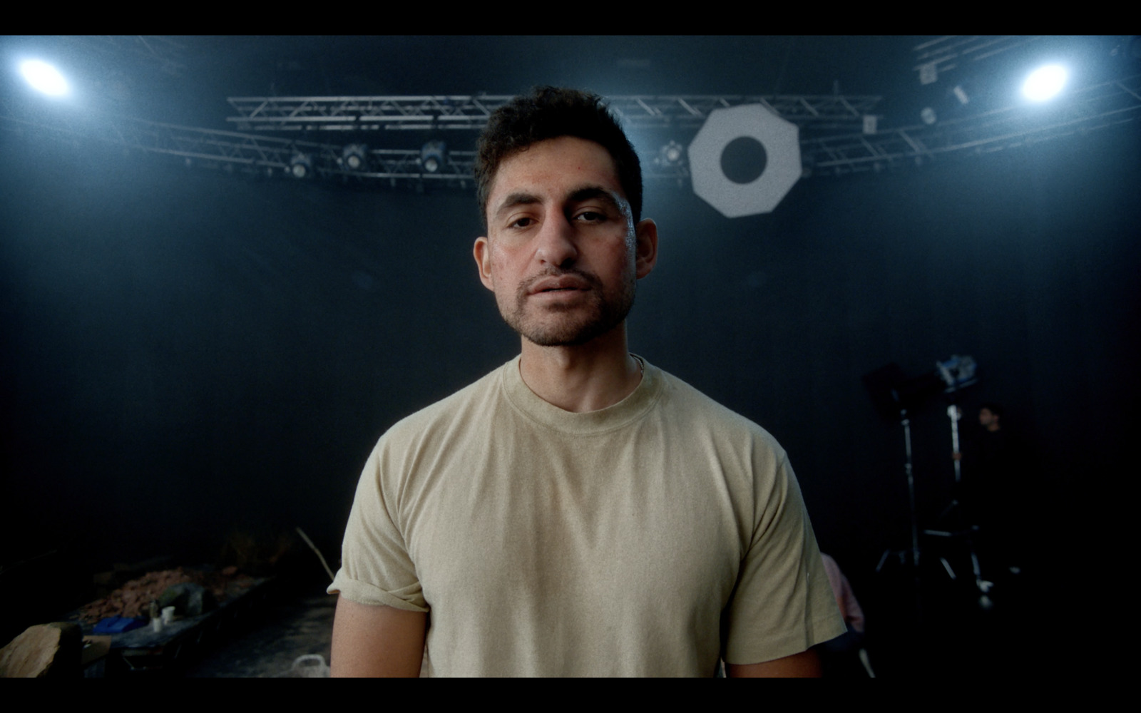 a man standing in front of a camera in a dark room