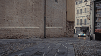 a car is driving down a cobblestone street