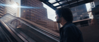 a man riding an escalator down a city street