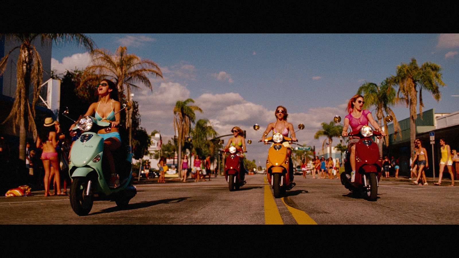 a group of people riding scooters down a street