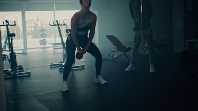 a woman standing in front of a mirror in a gym