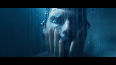 a woman in the rain holding her face to her face