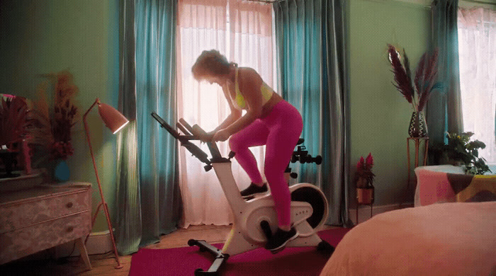 a woman on a stationary bike in a bedroom