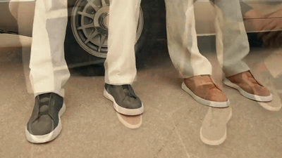 two men standing next to each other near a car