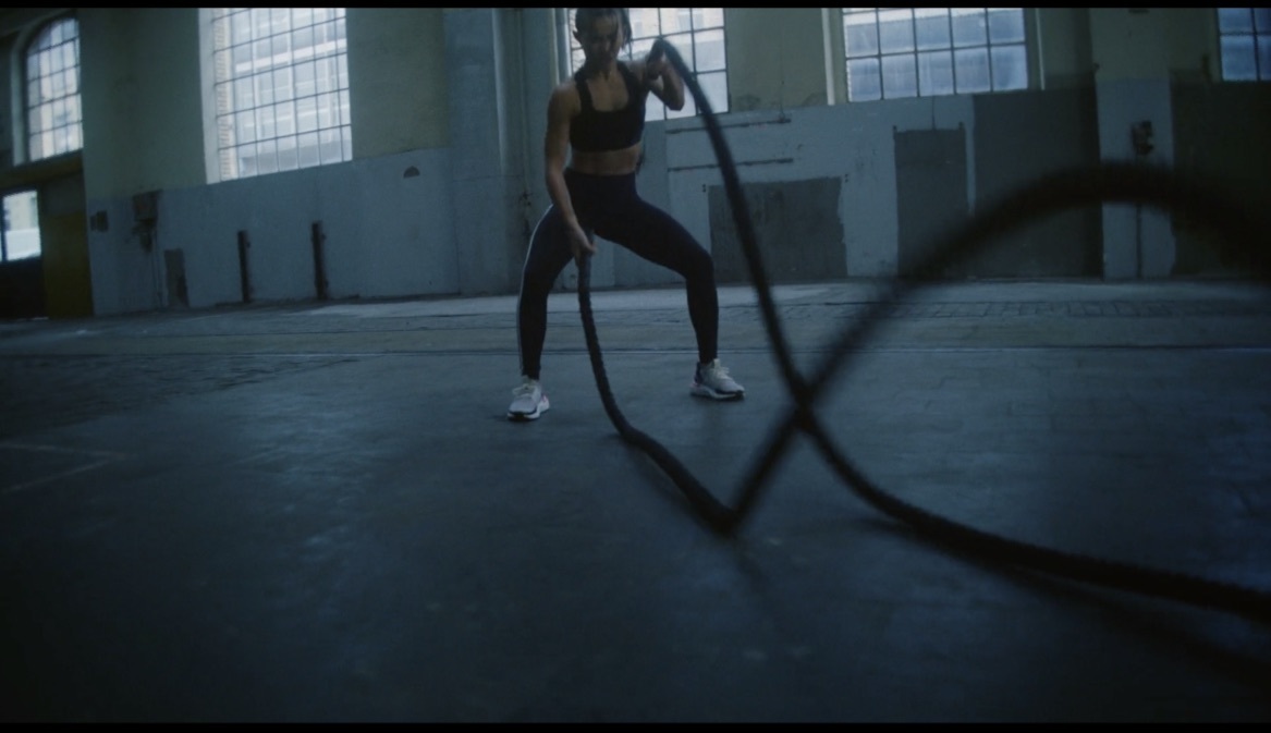 a woman in a gym holding a skipping rope