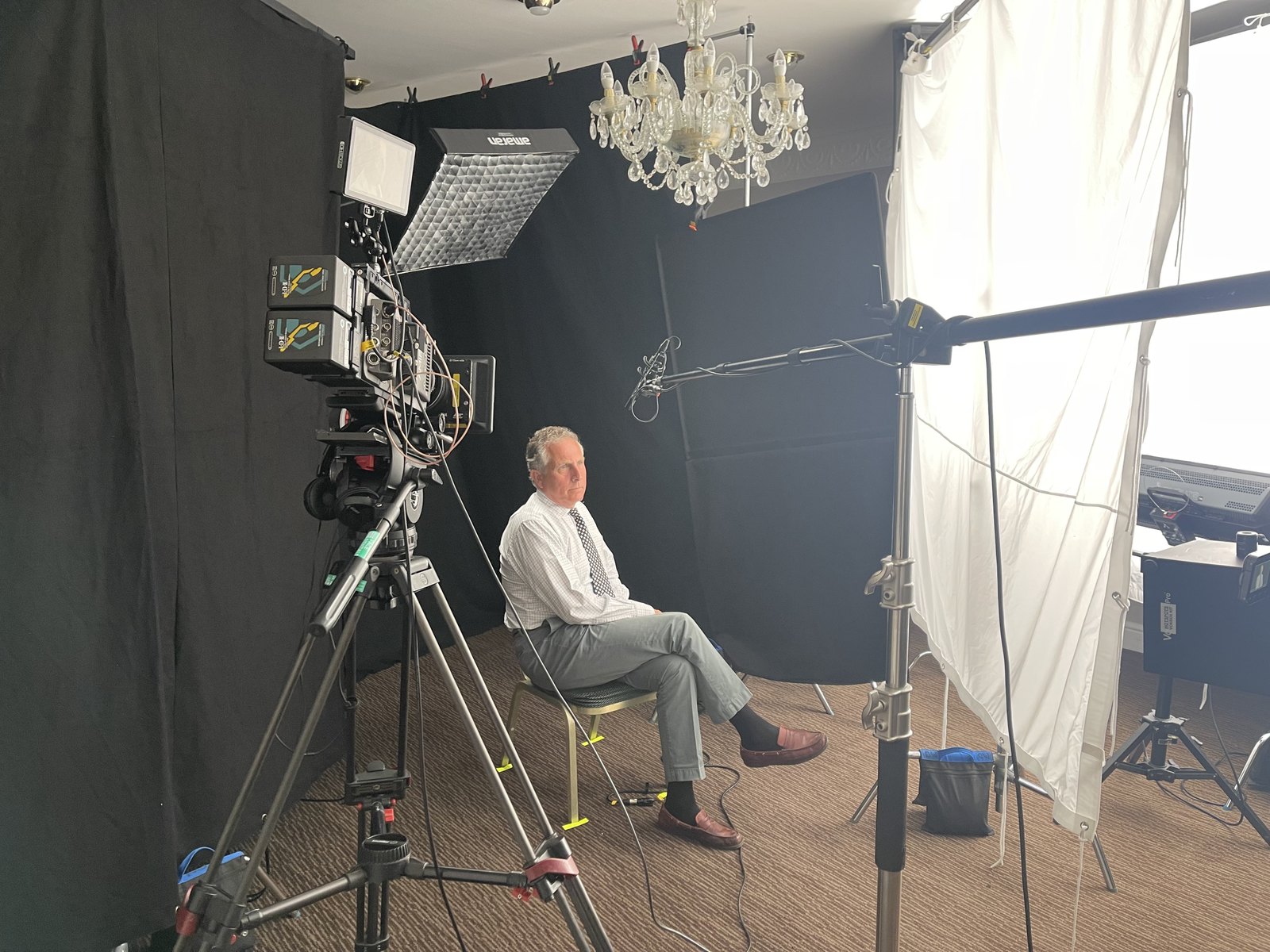 a man sitting in a chair in front of a camera