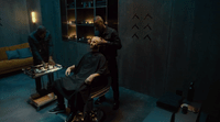 a man getting his hair cut at a barber shop