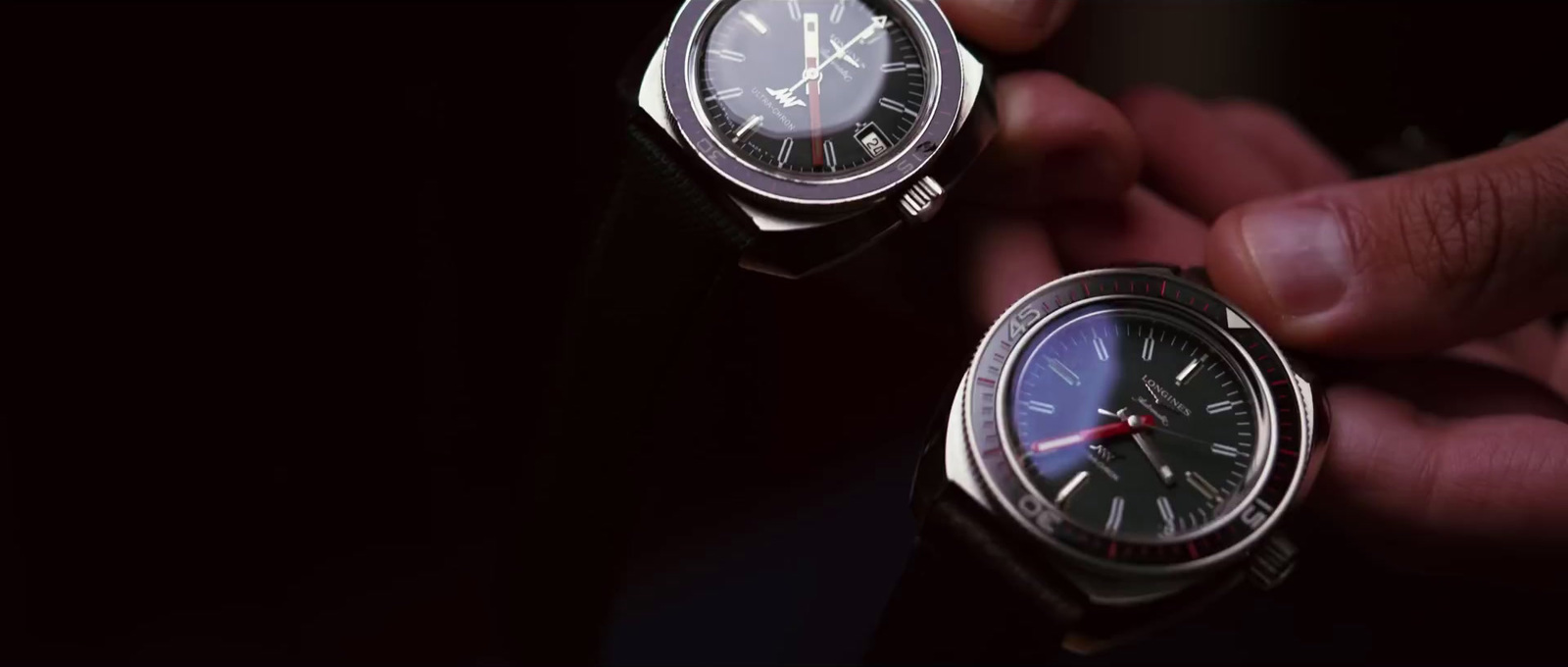 a person holding two watches in their hands