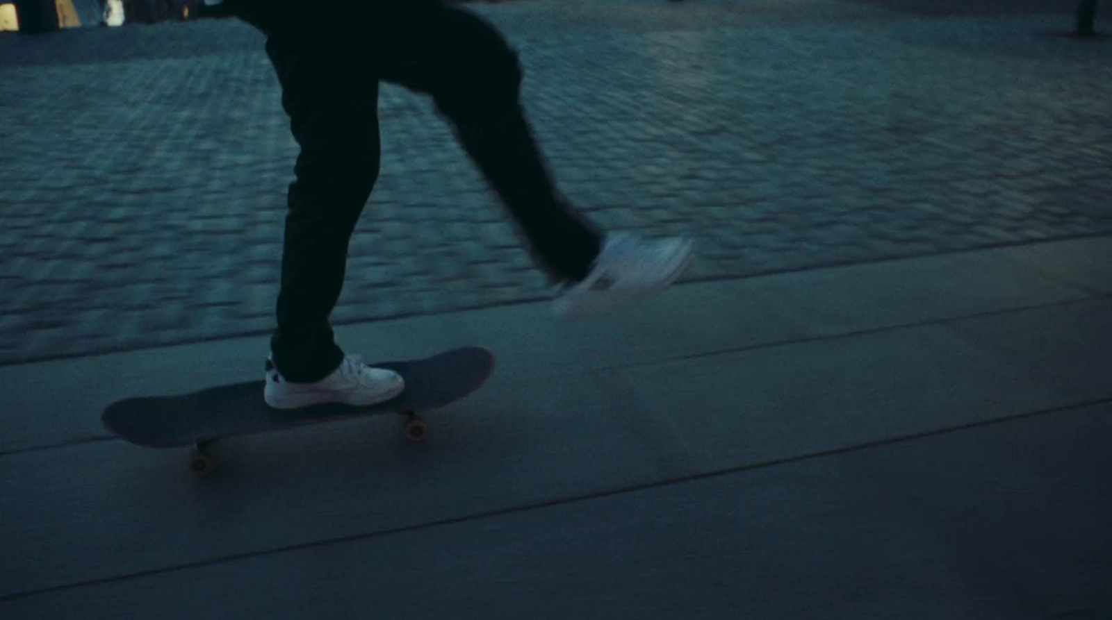 a person riding a skateboard down a sidewalk