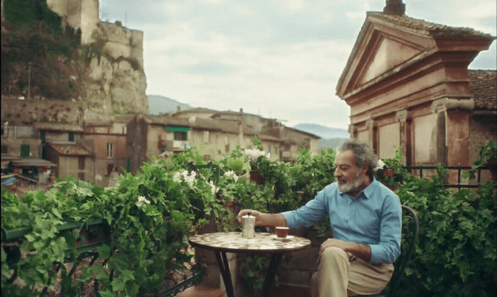 a man sitting at a table on a balcony