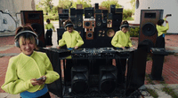 a woman standing next to a table with speakers on it