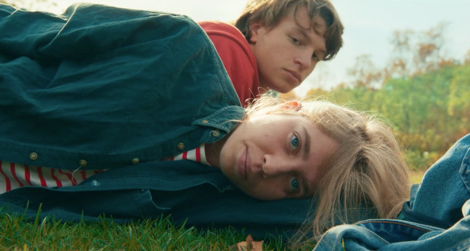 a man and a woman laying on the grass