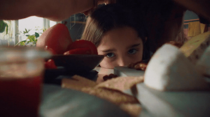 a girl is looking at a plate of food