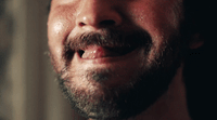 a close up of a man's face with a toothbrush in his mouth