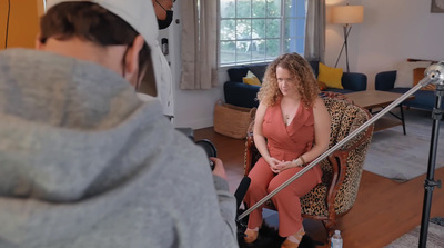 a woman sitting in a chair in front of a mirror