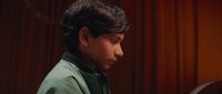 a young boy sitting at a desk with a laptop computer