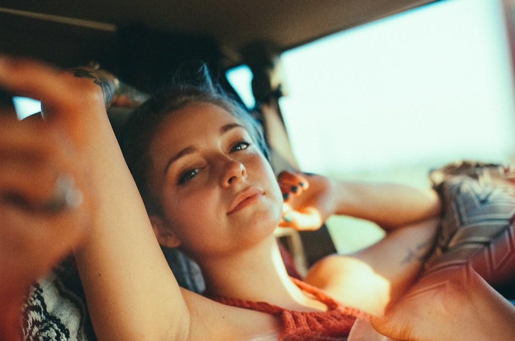 a young girl sitting in the back of a car