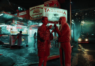 two people standing in front of a restaurant at night