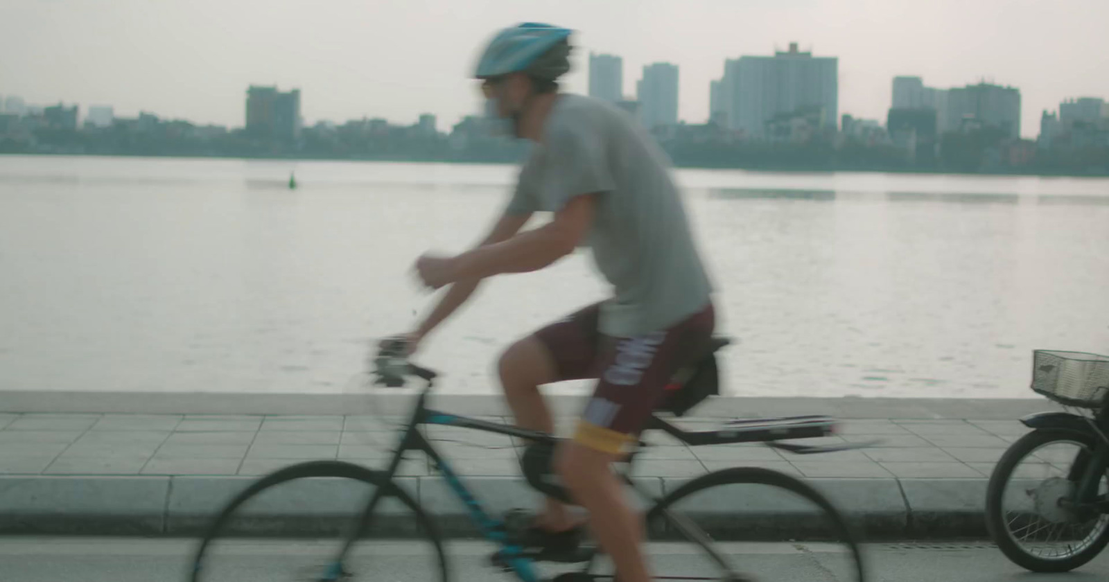 a man riding a bike next to a body of water