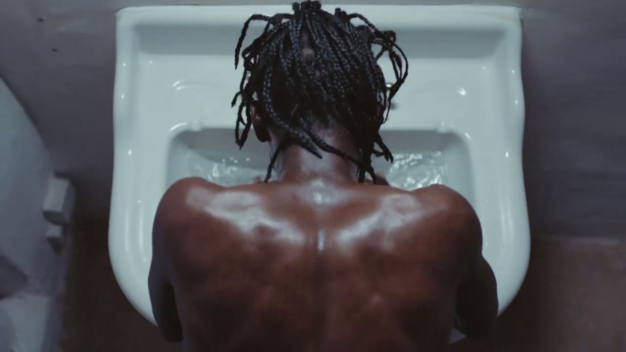 a man with dreadlocks sitting on a toilet