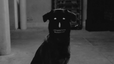 a black dog with a creepy face on it's face