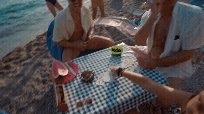 two women sitting at a table on the beach