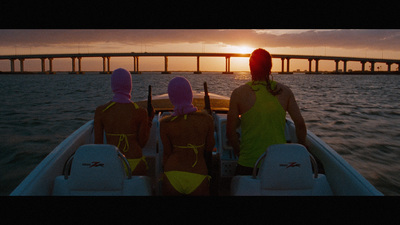 three people in bathing suits sitting in a boat