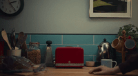 a kitchen counter with a red toaster on it