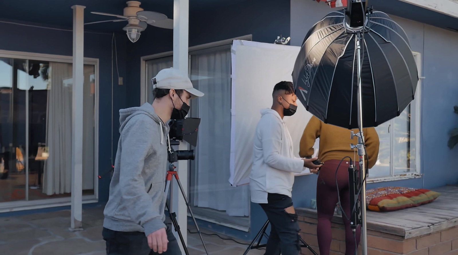 a couple of men standing in front of a camera