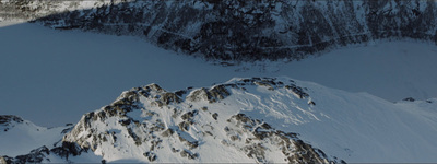 a person on a snowboard going down a snowy mountain