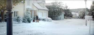 a snow covered street with houses and trees