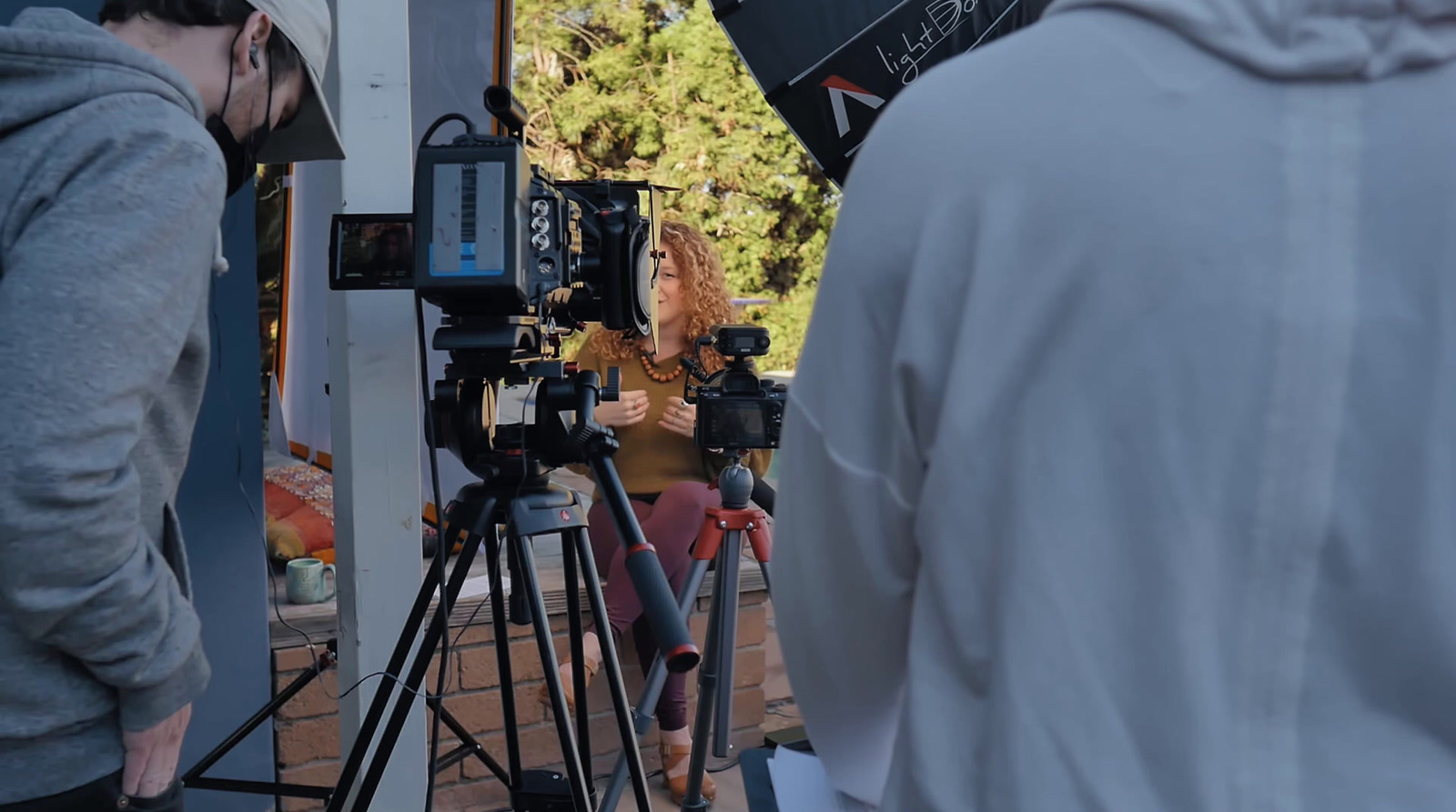 a woman standing in front of a camera on a tripod