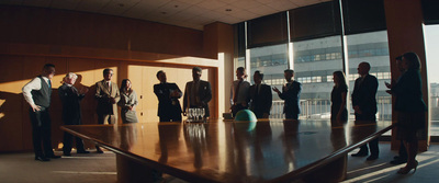 a group of people standing around a conference table