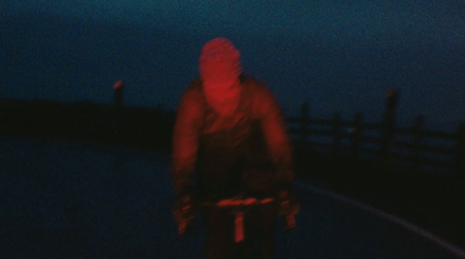 a man riding a bike down a street at night