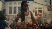 a woman standing in front of a table filled with food