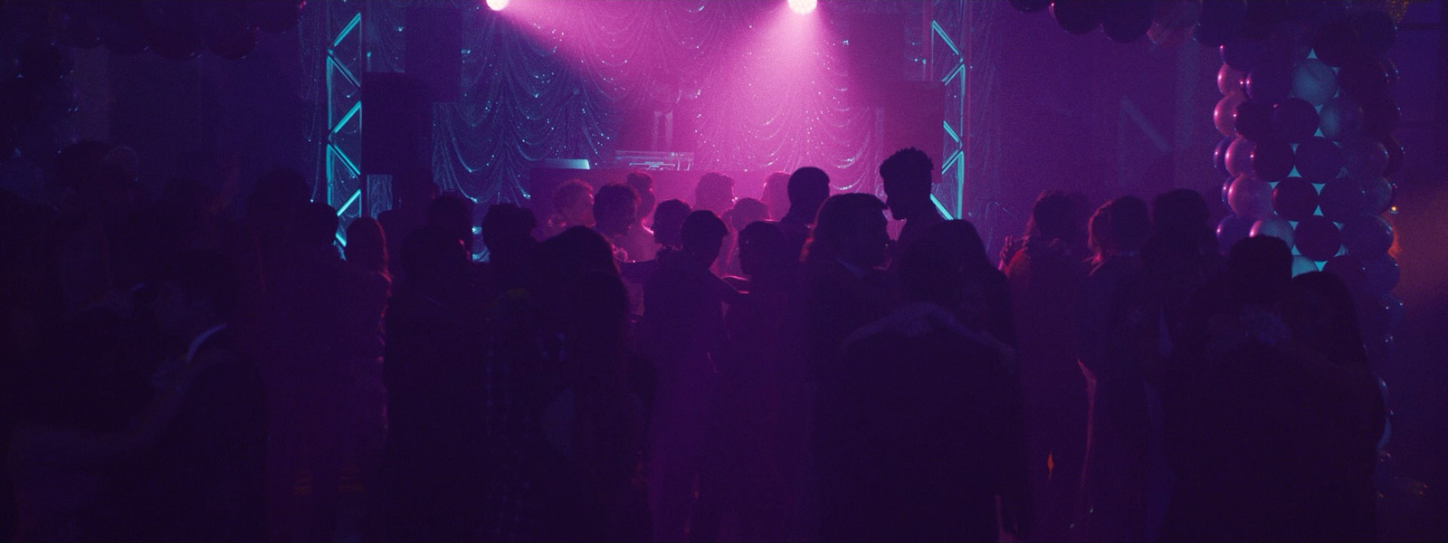 a group of people standing in front of a purple light