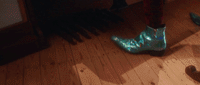 a pair of blue boots sitting on top of a wooden floor