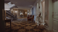 a woman in a white robe is entering a room