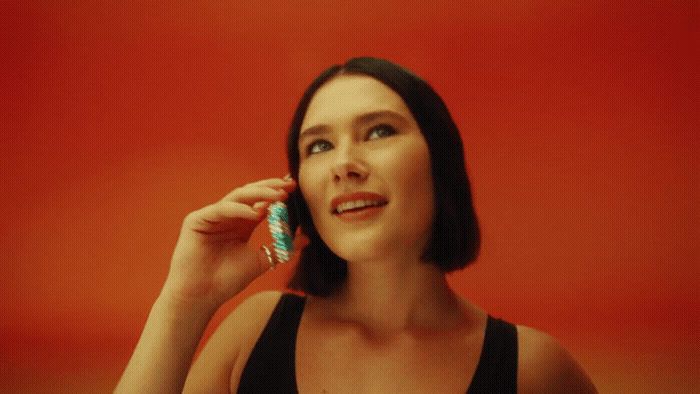 a woman holding a toothbrush to her ear