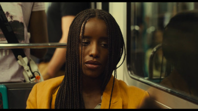 a woman with braids sitting on a bus