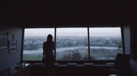 a woman standing in front of a large window