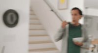 a man standing in a kitchen holding a bowl