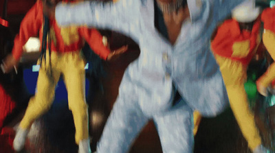 a blurry photo of a man in a blue suit and yellow pants