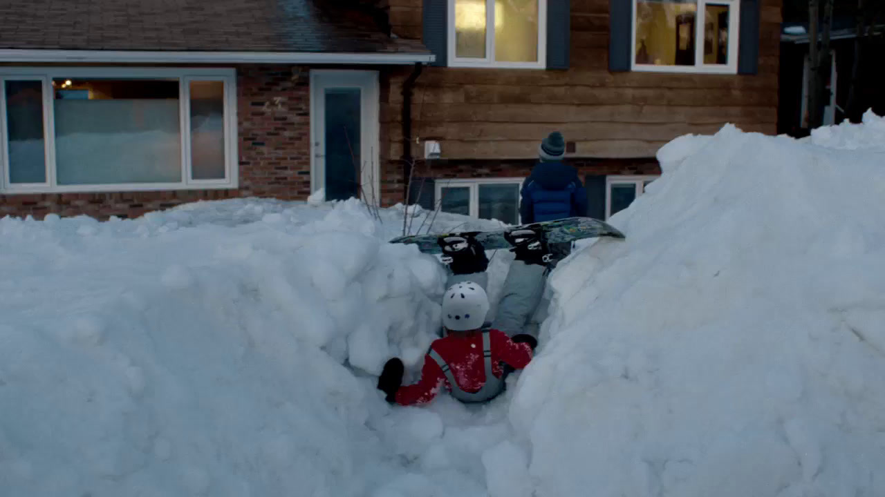 a person riding a snowboard on top of a pile of snow