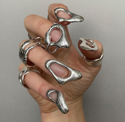 a woman's hand with silver rings and rings on it