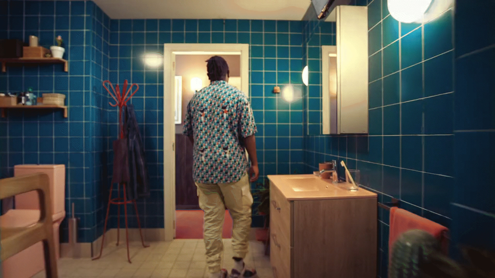 a man standing in a bathroom next to a sink