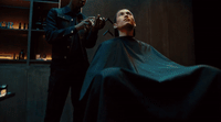 a man getting his hair cut by a barber