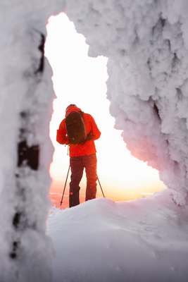 a man standing in the middle of a snow covered forest