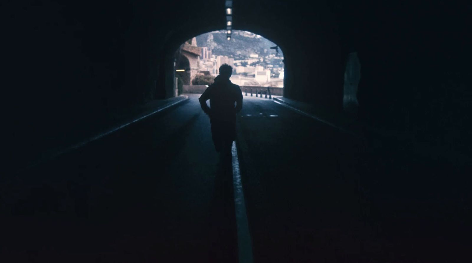 a person standing in a tunnel at night